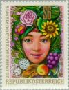 Colnect-137-010-Girls-head-surrounded-by-flowers-fruit-grain-grasses--amp--i.jpg