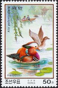 Colnect-1933-185-Mandarin-Duck-Aix-galericulata-Couple-in-Row-Boat.jpg